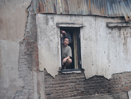 Một hộ gia đình bên cạnh ngôi nhà bị cháy ngao ngán nhìn hiện trường. Ảnh: Tuấn Nguyễn