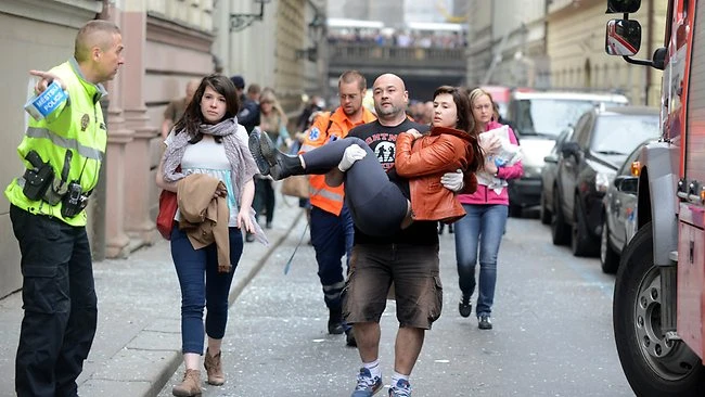 Một người đàn ông bế một phụ nữ bị thương trong vụ nổ kinh hoàng