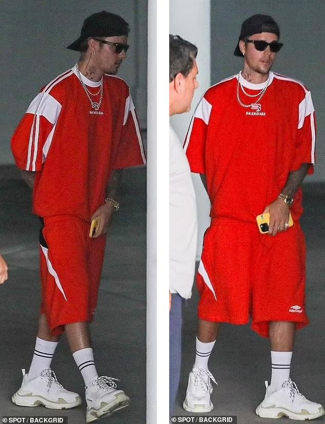 Trong khi đó, &quot;Hoàng tử nhạc Pop&quot; nổi bật với bộ đồ thể thao đỏ rực, kết hợp giày thể thao và tất trắng, kèm theo kính râm và mũ lưỡi trai đội ngược.