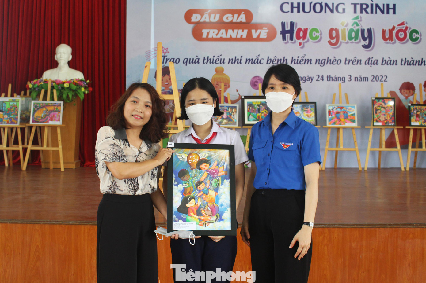 Chị Nguyễn Uyên Thao nhận bức tranh Nụ cười từ tay tác giả Nguyễn Ngọc Trâm Anh, chị đã đấu giá bức tranh này với giá 5,5 triệu đồng