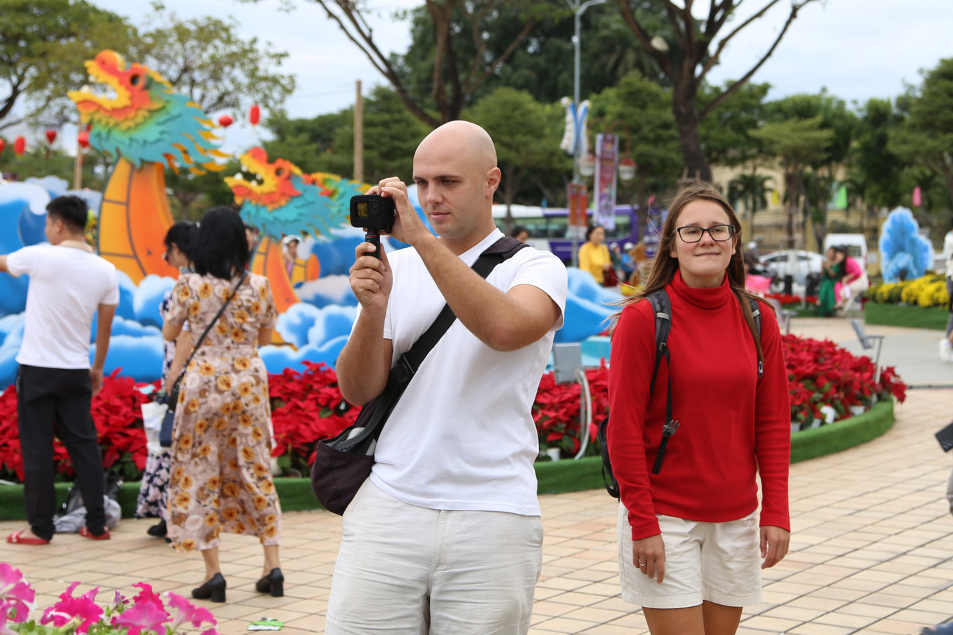 Du khách quốc tế thích thú trải nghiệm đường hoa Tết Đà Nẵng, nhiều người lấy điện thoại để chụp ảnh, quay phim lại người dân mặc trang phục áo dài truyền thống bên các tiểu cảnh rực rỡ. Du khách quốc tế thích thú trải nghiệm đường hoa Tết Đà Nẵng, nhiều người lấy điện thoại để chụp ảnh, quay phim lại người dân mặc trang phục áo dài truyền thống bên các tiểu cảnh rực rỡ.