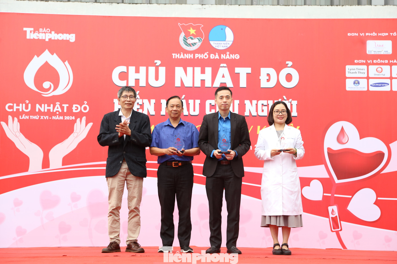 Đại diện Báo Tiền Phong trao kỷ niệm chương cho các đơn vị đã đồng hành, hỗ trợ tổ chức Ngày hội Chủ Nhật Đỏ trong suốt những năm qua, gồm Thành Đoàn - Hội LHTN TP. Đà Nẵng, Hội Chữ thập Đỏ thành phố, Khoa Huyết học Truyền máu - Bệnh viện Đà Nẵng.