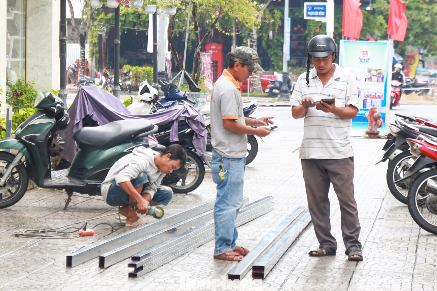 Thợ sắt, thợ hàn xì làm việc luôn tay để hoàn thiện khung sắt chèn cửa lớn, chống các cây to, cây cổ thụ ở trước và trong khuôn viên các khách sạn.