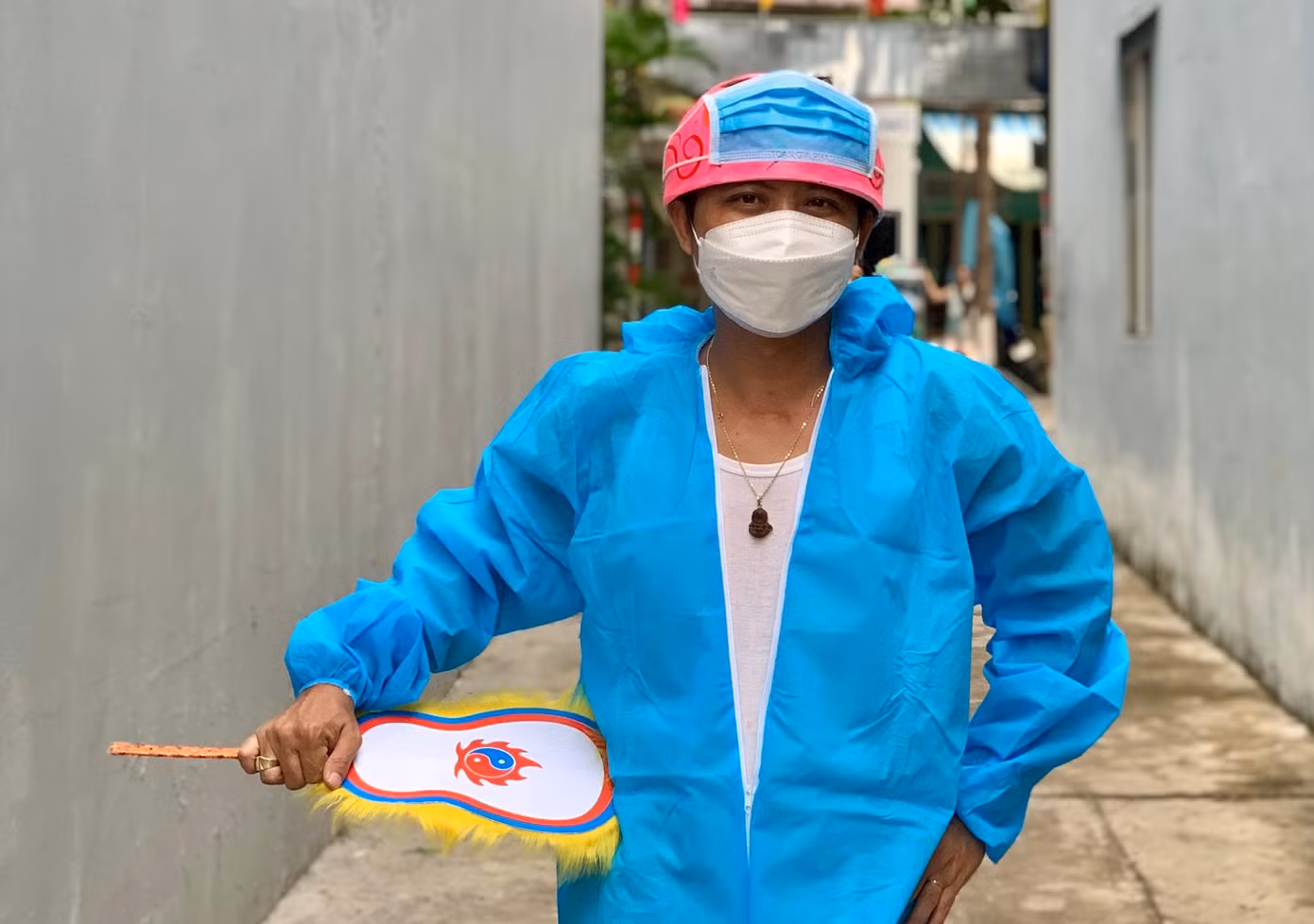 "Ông Địa" Đặng "lên đồ" bảo hộ, đeo mặt nạ và cầm quạt phe phẩy đến từng nhà trong khu dân cư để phát quà Trung thu cho các em nhỏ.