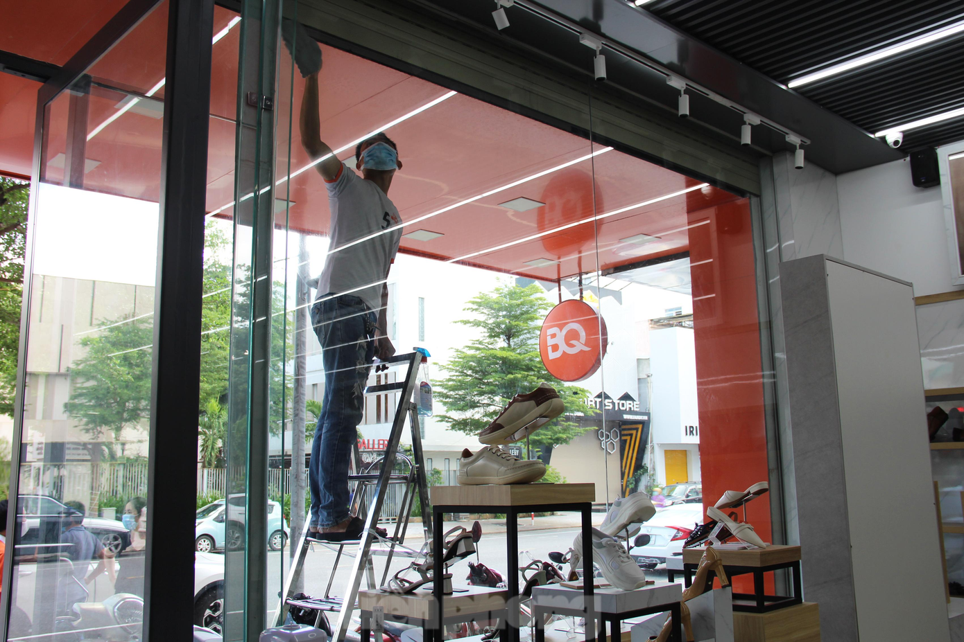 Tại cửa hàng giày trên đường Lê Duẩn, khoảng 3 - 4 nhân viên đang dọn dẹp lau chùi cửa hàng, tiếp nhận hàng hóa mới về... Cửa hàng này cũng lắp đặt hệ thống đo thân nhiệt kết hợp sát khuẩn tay tự động, máy quét QR Code, hệ thống kính chắn ở quầy thu ngân, các vạch phân luồng, bảng hướng dẫn khách mua sắm đảm bảo giãn cách. Tại cửa hàng giày trên đường Lê Duẩn, khoảng 3 - 4 nhân viên đang dọn dẹp lau chùi cửa hàng, tiếp nhận hàng hóa mới về... Cửa hàng này cũng lắp đặt hệ thống đo thân nhiệt kết hợp sát khuẩn tay tự động, máy quét QR Code, hệ thống kính chắn ở quầy thu ngân, các vạch phân luồng, bảng hướng dẫn khách mua sắm đảm bảo giãn cách.