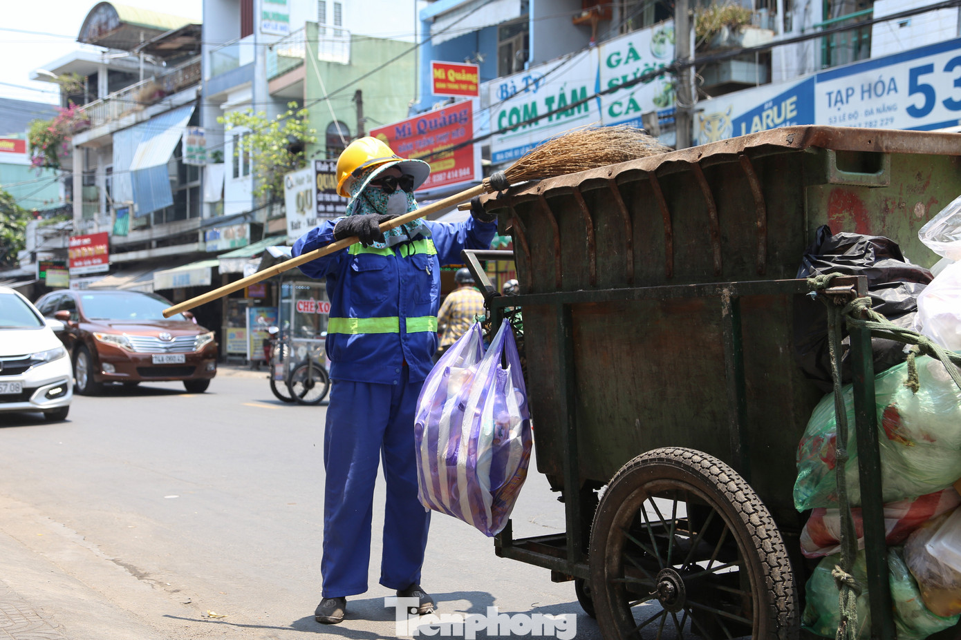 Một công nhân vệ sinh môi trường bịt kín như bưng khi dọn rác ở khu vực đường Trần Cao Vân (quận Thanh Khê, Đà Nẵng) vào giữa trưa nắng.