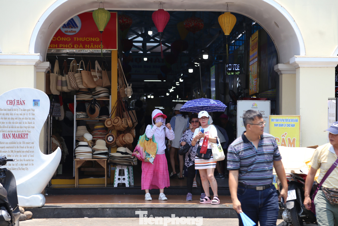 Sau khi kết thúc chuyến tham quan ở Chợ Hàn, một đoàn khách Trung Quốc trùm kín đồ chống nắng, chuẩn bị ô để tránh nắng nóng khi di chuyển đến địa điểm khác.