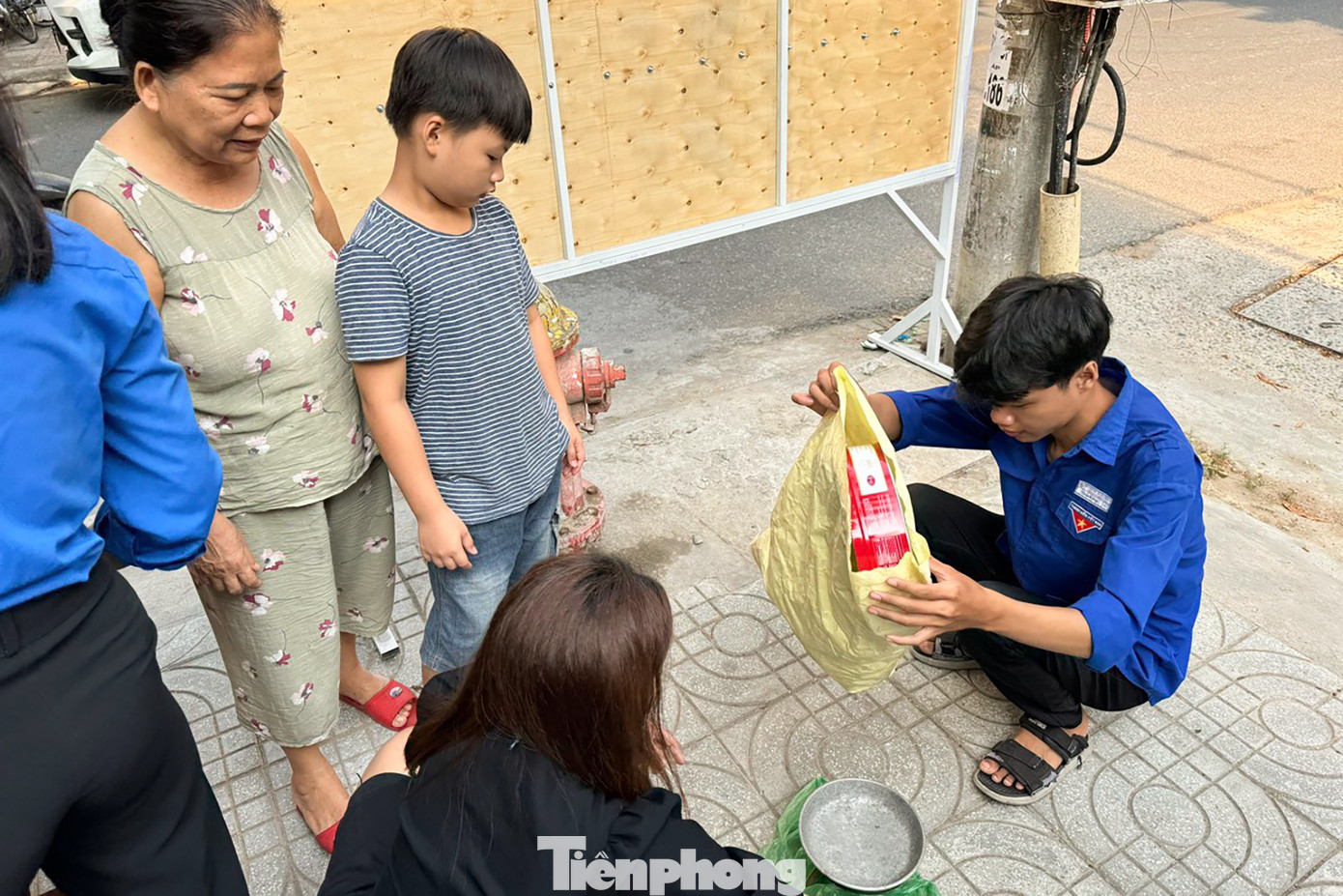 Các tình nguyện viên hỗ trợ người dân cân giấy, đếm lon để quy đổi qua thực phẩm, rau củ quả.