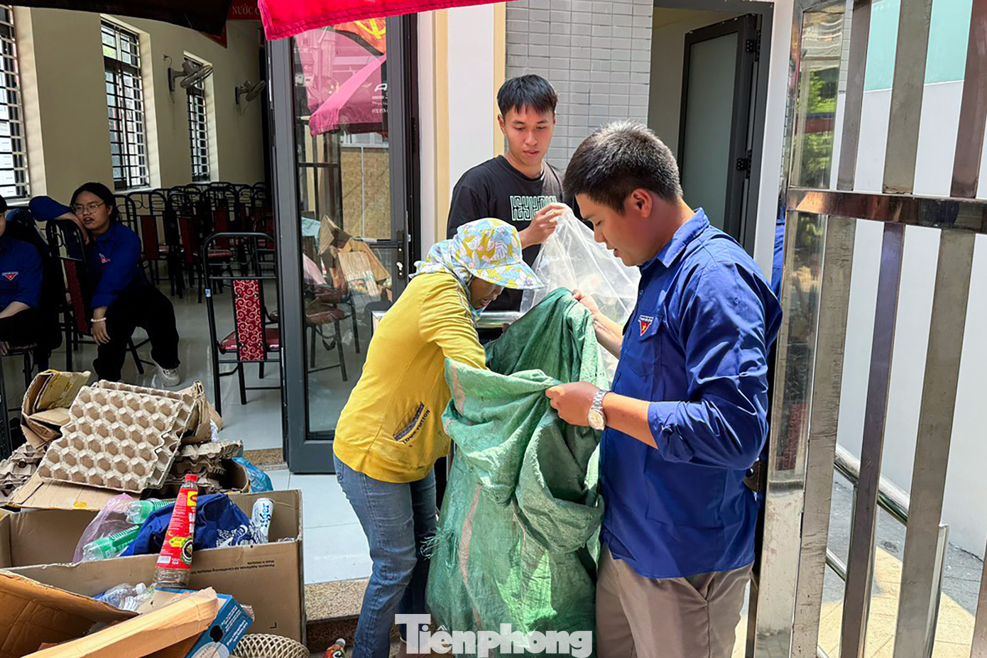 Các tình nguyện viên hỗ trợ người dân cân giấy, đếm lon để quy đổi qua thực phẩm, rau củ quả.