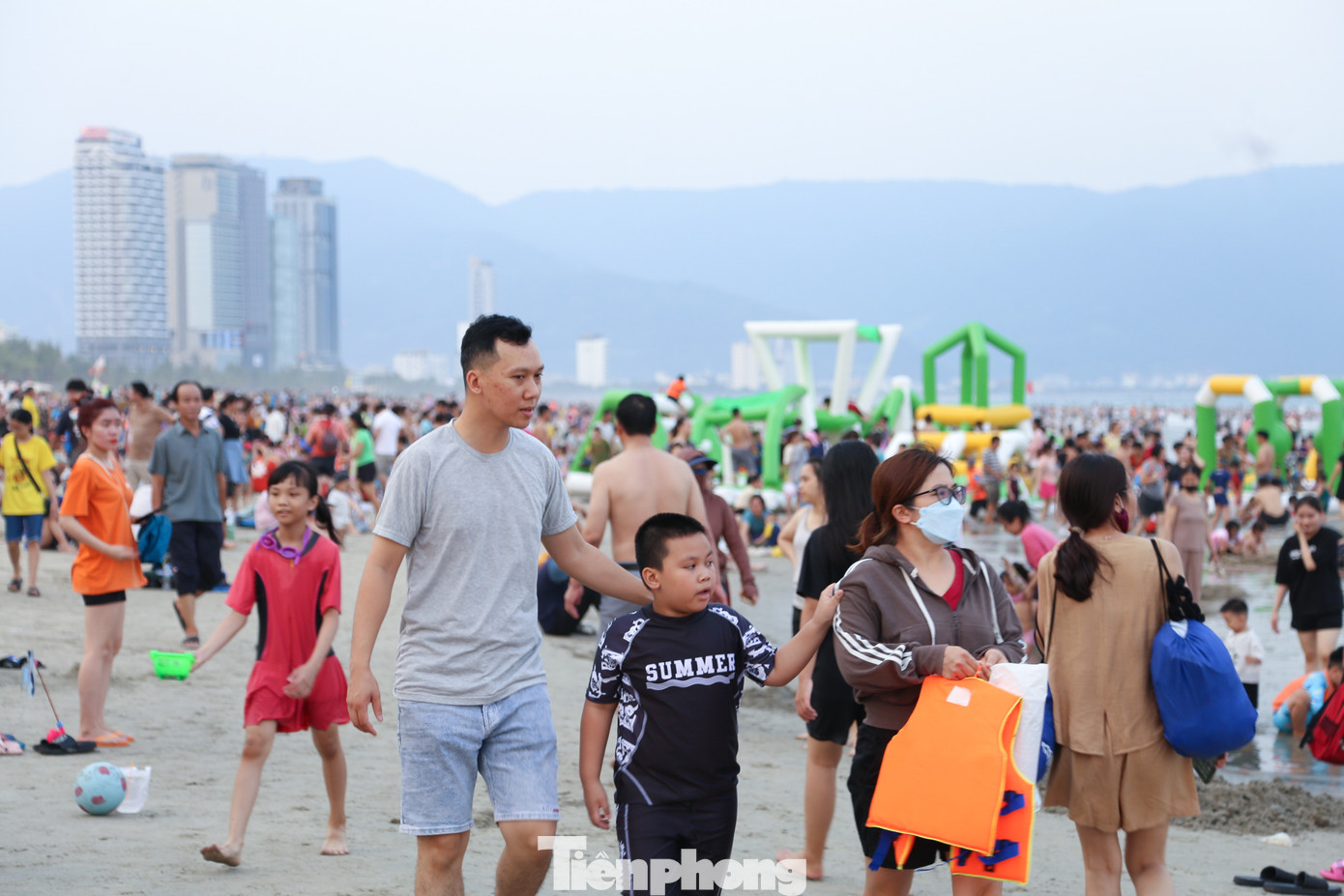 Càng về chiều, dòng người đổ về khu vực các bãi tắm ngày càng đông. Các bãi tắm như Phạm Văn Đồng, T20, Mỹ Khê... đều đông kín người. Theo chị Nguyễn Thị Hải Yến (35 tuổi, quận Sơn Trà), dù biển rất đông đúc nhưng không khí vẫn mát mẻ, thoải mái hơn so với ở nhà. Chiều nào gia đình chị cũng ra biển cho các cháu vui chơi, tắm biển. Ảnh: Giang Thanh.