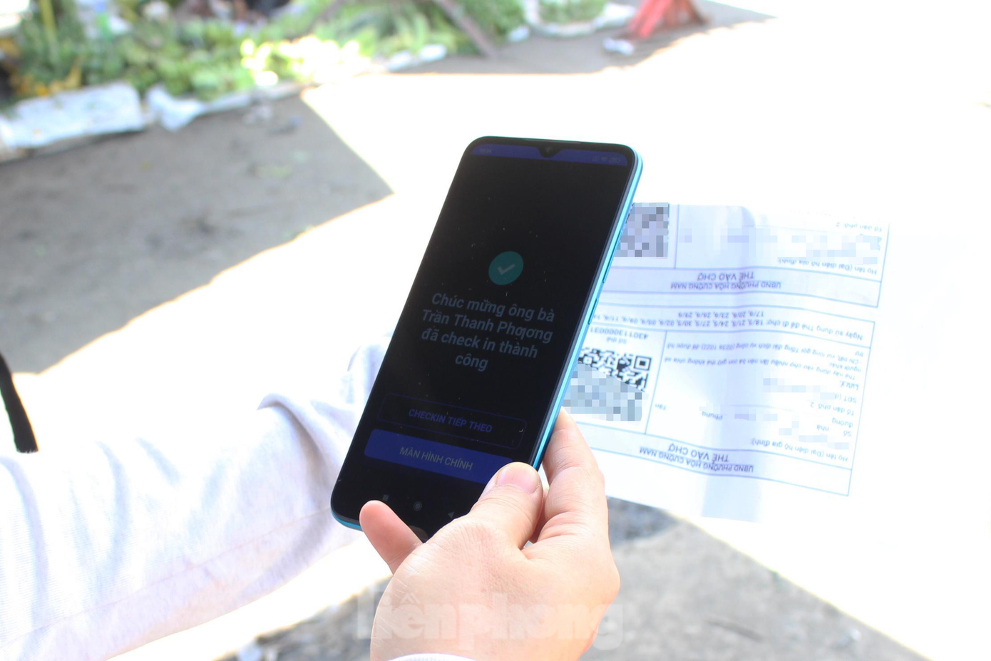 Quá trình vào chợ bằng thẻ đi chợ QR Code chỉ mất khoảng 15 - 30 giây đối với mỗi người. Những trường hợp dùng thẻ đi chợ "trắng" (chưa có thông tin cá nhân), nhân viên của BQL sẽ nhắc nhở họ điền thông tin vào phiếu, chụp ảnh lại để đi chợ cho lần sau và thu lại thẻ để cập nhật thông tin lên hệ thống cơ sở dữ liệu. Ảnh: Giang Thanh