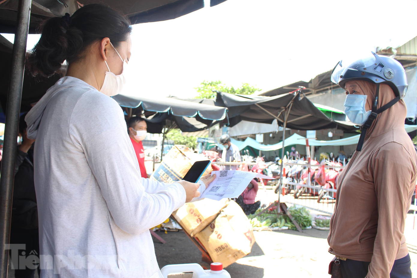 Khi vào chợ, người dân chỉ cần đưa thẻ vé có mã QR Code để nhân viên BQL chợ quét mã. Nếu hiển thị checkin thành công, người dân có thể nhanh chóng vào chợ. Ảnh: Giang Thanh