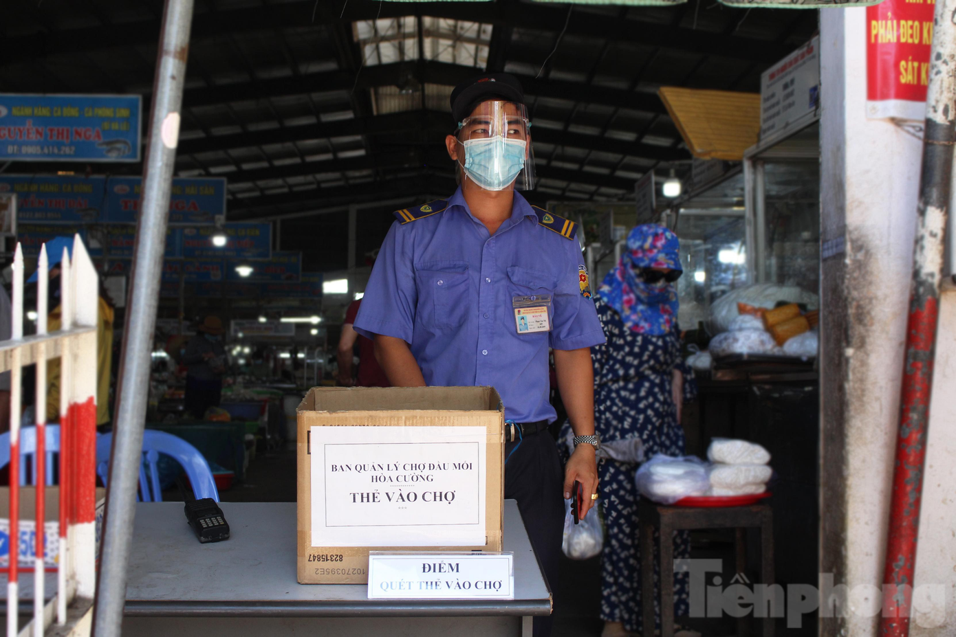 Sáng 24/5, chợ đầu mối Hòa Cường (quận Hải Châu, Đà Nẵng) bố trí thêm tấm bảng "Điểm quét thẻ vào chợ" ở 4 khu vực cổng. Ngoài chiếc máy đo nhiệt độ thường ngày, nhân viên ở các cổng được trang bị thêm smartphone cài đặt sẵn ứng dụng eTicket-Đà Nẵng. Ảnh: Giang Thanh
