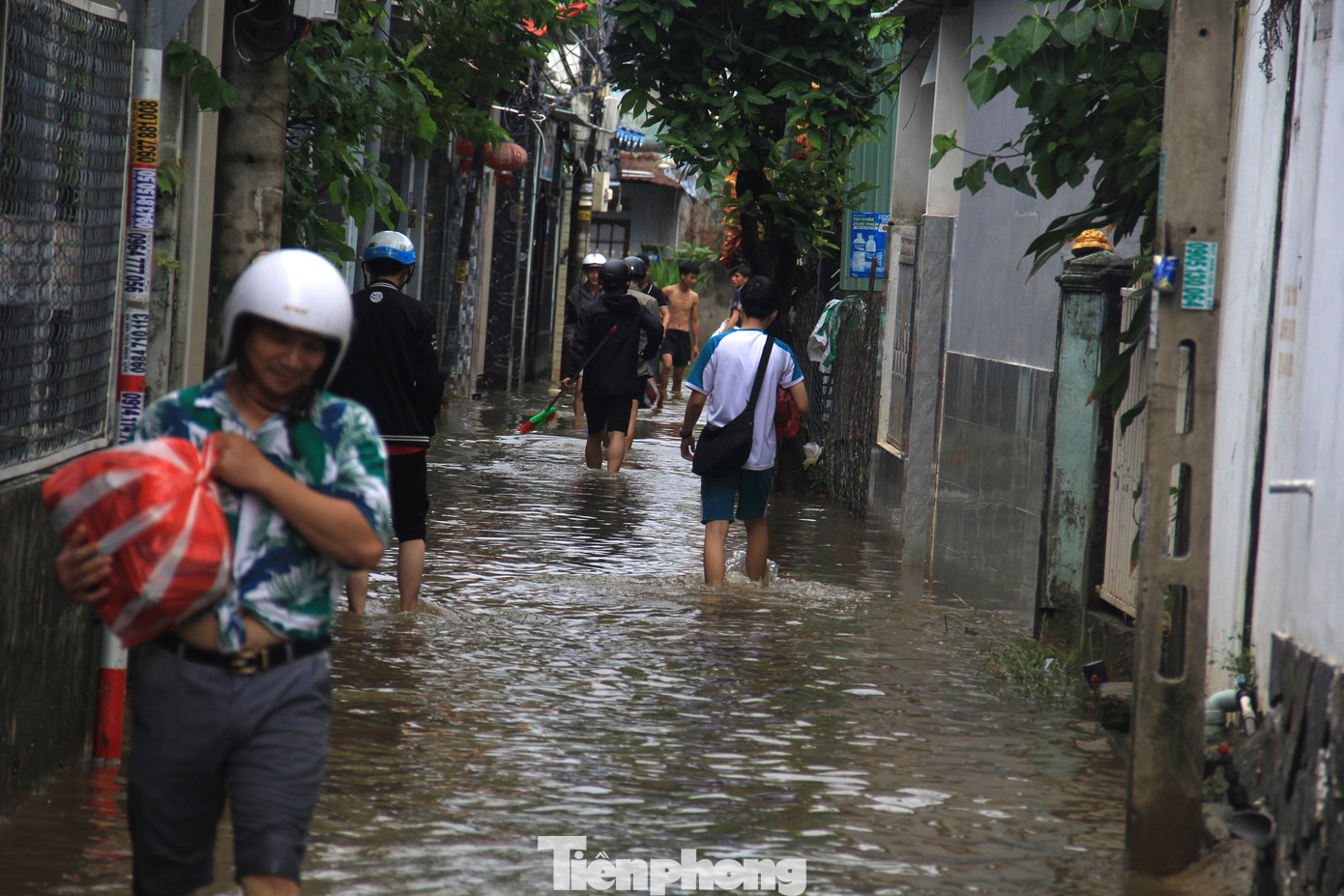 Hàng loạt nhà dân trên đường Mẹ Suốt (quận Liên Chiểu) đến trưa nay vẫn ngập. Càng vào sâu trong các kiệt hẻm, nước càng ngập sâu. Anh Thành (45 tuổi) cho hay, nhà anh hôm qua ngập cả mét. Máy giặt, tủ lạnh đều bị ngâm nước. Thấy mưa dai dẳng, cả nhà anh sơ tán. Sáng nay về, nước vẫn ở lì trong nhà, ngang đầu gối. Anh lấy vội tập sách vở mang đi cho con đến trường vào ngày mai. (Ảnh: Thanh Trần).