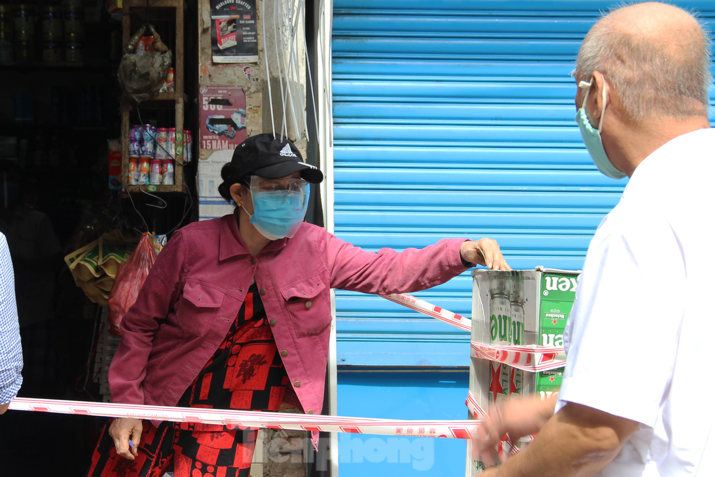 Các quầy tạp hóa tấp nập người mua. Chủ quán giăng dây ngăn cách và liên tục nhắc nhở người dân giữ khoảng cách, xếp hàng để đảm bảo an toàn.