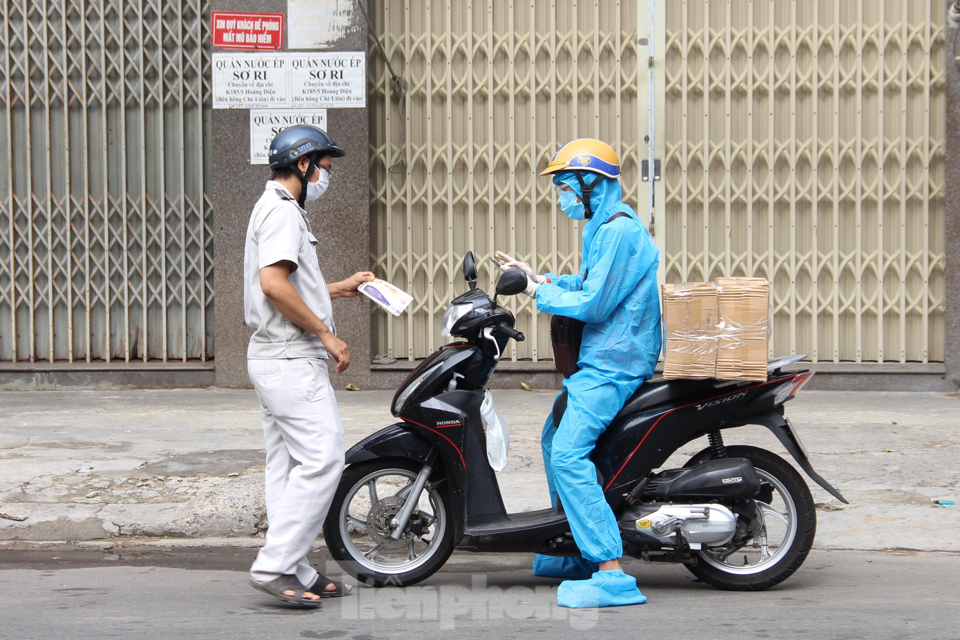 Các trường hợp vùng vàng, vùng đỏ đi qua vùng xanh phải có giấy đi đường hoặc lí do chính đáng, phải đảm bảo phòng hộ theo quyết định mới của UBND TP. Trong ảnh, lực lượng tổ kiểm soát lưu động kiểm tra giấy đi đường của một shipper đi ngang qua địa bàn phường.