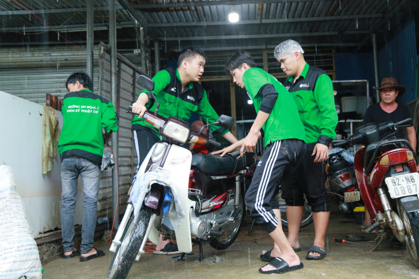 Nhận xe, các tình nguyện viên trong đội tất bật tháo lắp, kiểm tra bugi, bình điện, bình nhớt... Đây đã là năm thứ 2, Đội SOS ĐH Đông Á hỗ trợ sửa chữa xe máy ngập lụt cho người dân các vùng trũng sâu.