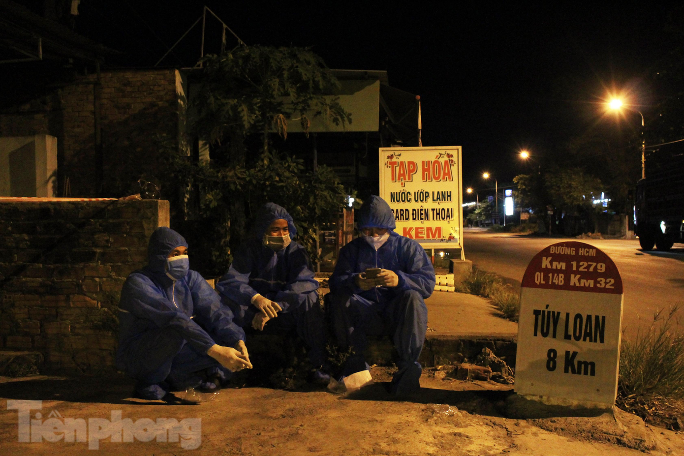 Rạng sáng ngày 28/7, khu vực chốt kiểm soát xã Hòa Khương (huyện Hòa Vang, Đà Nẵng), khoảng 15 bạn trẻ trong trang phục bảo hộ, xách trên tay hộp đồ nghề sửa xe máy chờ đợi đoàn người di chuyển về quê tránh dịch từ TPHCM. Ảnh: Giang Thanh