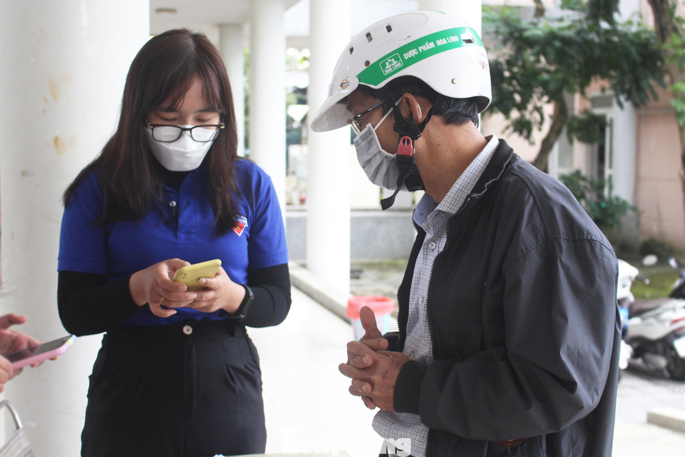 Các tình nguyện viên hỗ trợ người dân khai báo y tế trước khi vào khu vực mua sắm Các tình nguyện viên hỗ trợ người dân khai báo y tế trước khi vào khu vực mua sắm