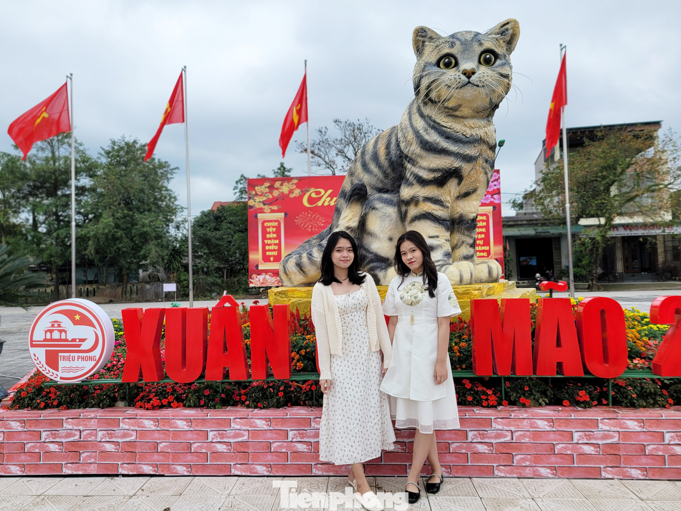 Đi hơn 10km từ TP Đông Hà đến TT Ái Tử để tận mắt chiêm ngưỡng hoa hậu của làng linh vật mèo năm nay, Lê Thị Kim Ngân và Nguyễn Thị Minh Châu (SN 2004) thích thú tạo dáng bên cạnh chú mèo dễ thương này. Ảnh: Giang Thanh