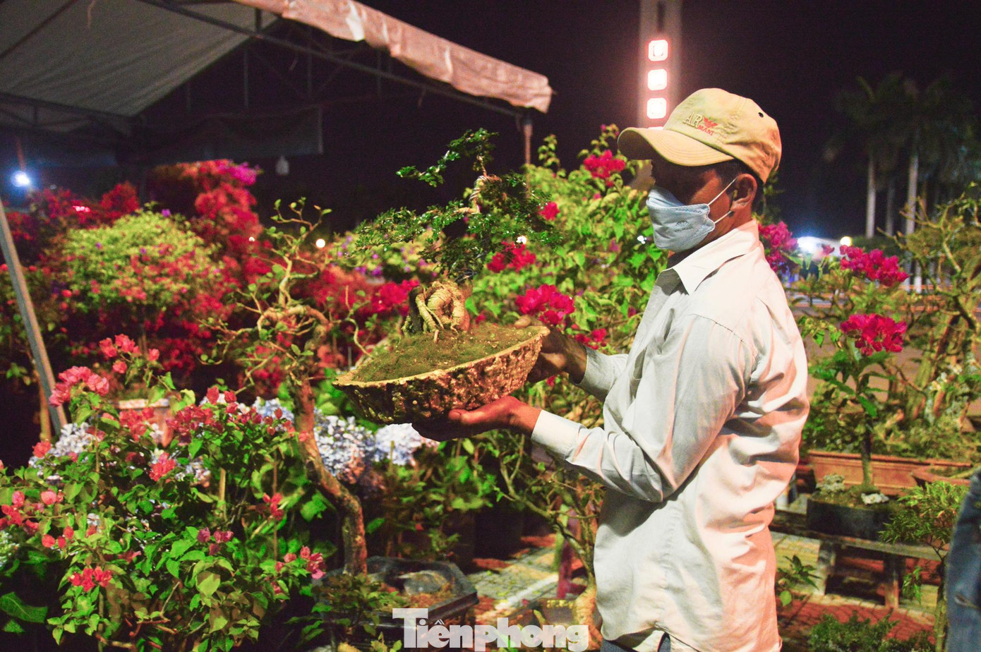 Anh Huỳnh Văn Sang bê những chậu bon sai nhỏ vào lán để cất trước khi tranh thủ ngả lưng Anh Huỳnh Văn Sang bê những chậu bon sai nhỏ vào lán để cất trước khi tranh thủ ngả lưng