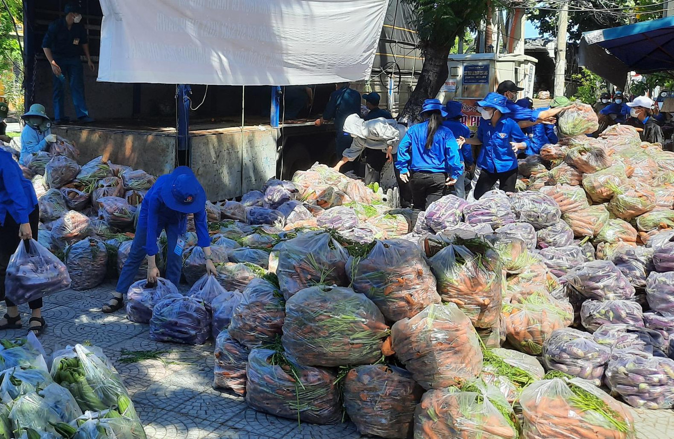 "Từ trưa hôm qua tới nay, những chuyến xe chở rau củ liên tục đổ hàng xuống, lực lượng tình nguyện viên làm việc không ngơi tay để bốc dỡ, phân loại rau củ, loại bỏ phần dập héo, hư hỏng rồi phân chia ra các túi nhỏ để chia về các tổ dân phố, từ đó chuyển đến tay người dân. Vì đảm bảo yêu cầu phòng, chống dịch nên số lượng đoàn viên hạn chế. Tuy nhiên, chúng tôi cùng với lực lượng khác làm 200% sức mình để rau củ nhanh chóng tới tay người dân", anh Thành nói. "Từ trưa hôm qua tới nay, những chuyến xe chở rau củ liên tục đổ hàng xuống, lực lượng tình nguyện viên làm việc không ngơi tay để bốc dỡ, phân loại rau củ, loại bỏ phần dập héo, hư hỏng rồi phân chia ra các túi nhỏ để chia về các tổ dân phố, từ đó chuyển đến tay người dân. Vì đảm bảo yêu cầu phòng, chống dịch nên số lượng đoàn viên hạn chế. Tuy nhiên, chúng tôi cùng với lực lượng khác làm 200% sức mình để rau củ nhanh chóng tới tay người dân", anh Thành nói.