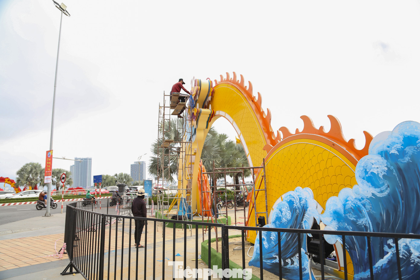 Cổng chính của đường hoa Tết Đà Nẵng tại khuôn viên bờ Tây cầu Rồng đang dần được hoàn thiện. Ngay sau cổng vào là cụm tiểu cảnh lấy cảm hứng từ truyền thuyết Lạc Long Quân và Âu Cơ, 50 con theo cha xuống biển và 50 con theo mẹ lên núi.