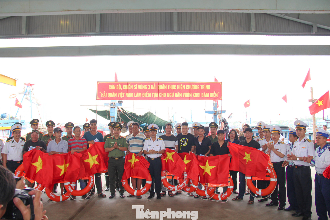 Tặng cờ, áo phao và phao tròn cho 30 ngư dân ở Cảng cá Thọ Quang. Ảnh: Giang Thanh