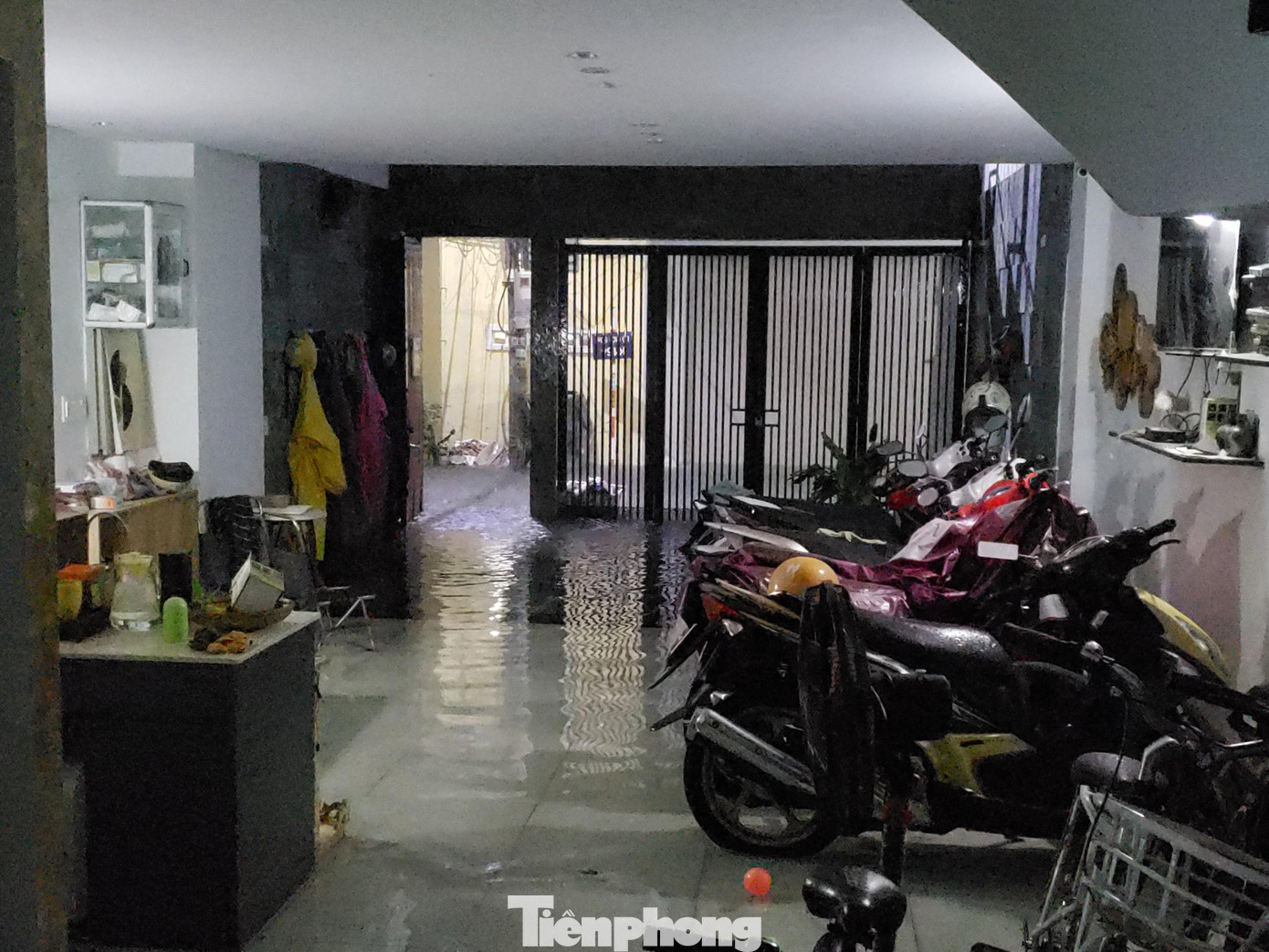 19h tối 14/10, gia đình bà Dương Thị Vọng (K154, đường Lý Tự Trọng, phường Thanh Bình, quận Hải Châu) vội vàng bê đồ đạc trong nhà lên kê cao và cắt cầu dao điện vì nước từ đường tràn vào khu vực tầng 1. Ảnh: Giang Thanh