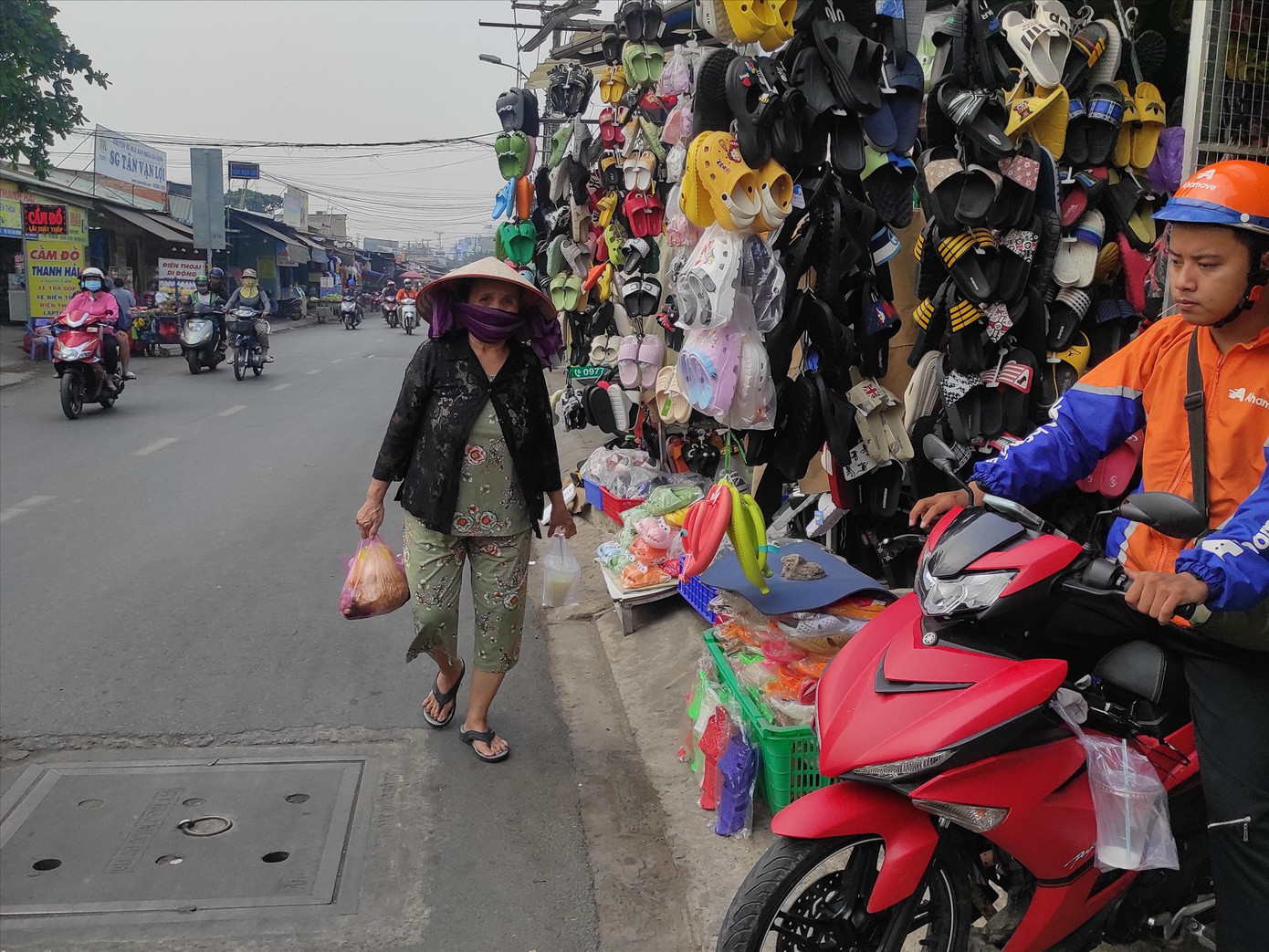 Người đi bộ bị đẩy xuống đường vì vỉa hè bị chiếm dụng (hình ảnh ghi nhận tại đường An Dương Vương, phường An Lạc, quận Bình Tân). Ảnh: H.H.