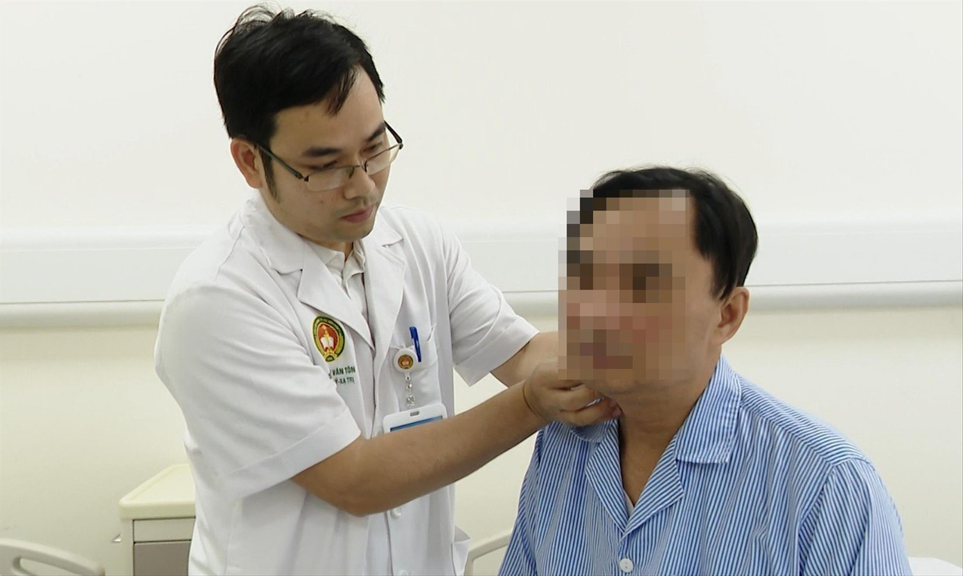 Thiếu tá Trần Văn Tôn thăm khám cho bệnh nhân ung thư đầu cổ. ẢNH: NVCC