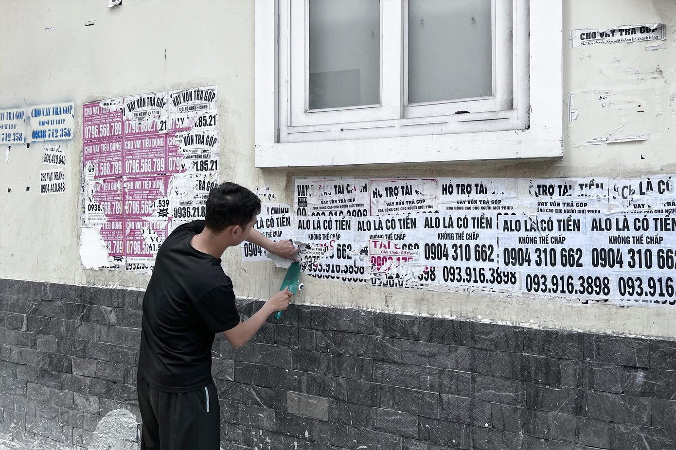 Công an đưa một bị can đi cạo xóa các tờ rơi quảng cáo vay tiền dán trên tường Công an đưa một bị can đi cạo xóa các tờ rơi quảng cáo vay tiền dán trên tường