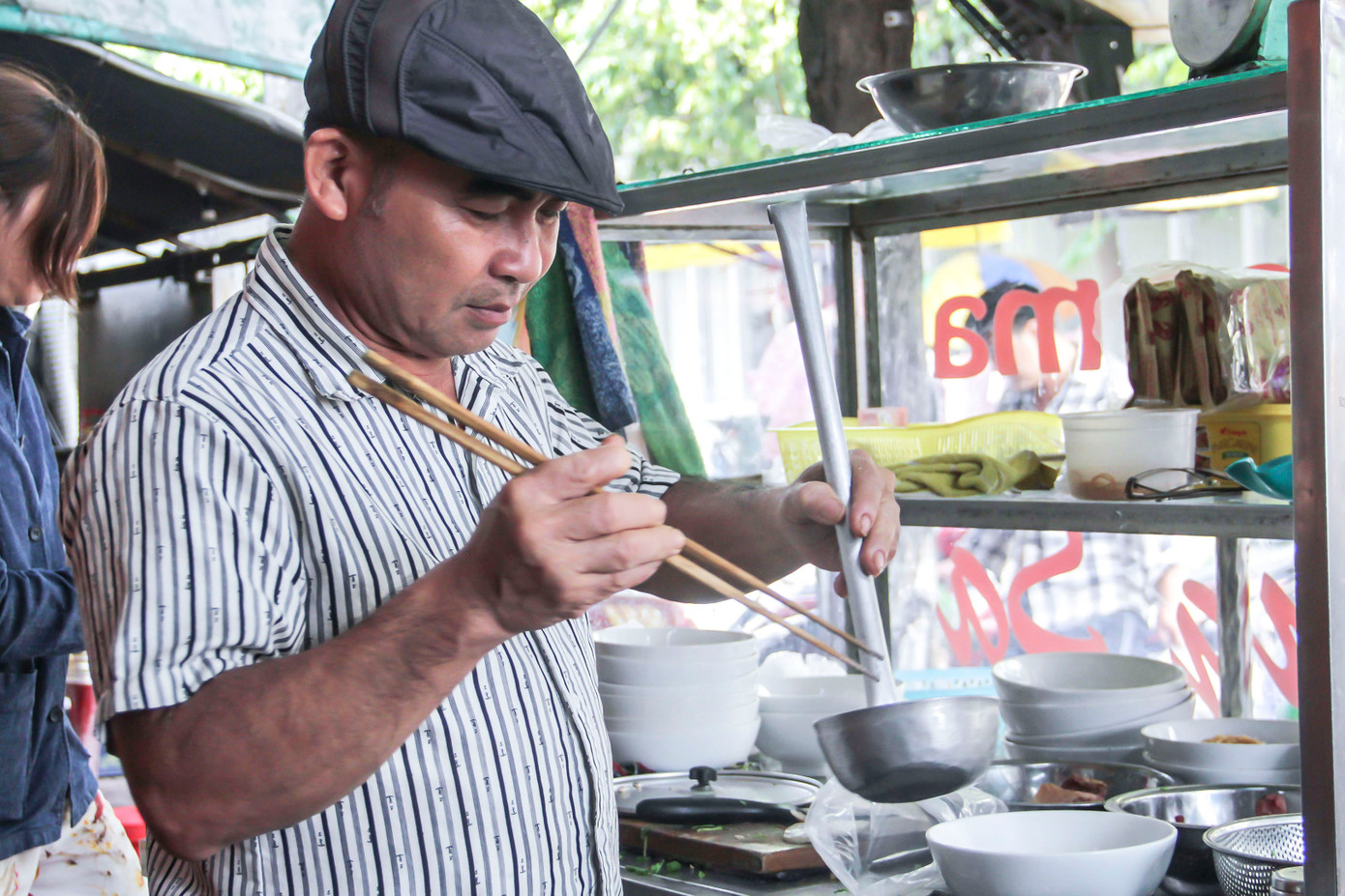 Cựu binh Lê Minh Thoa với quán phở Gạc Ma. Ảnh: Trương Định