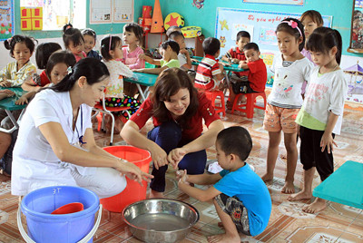 Cán bộ dự phòng hướng dẫn trẻ Trường Mầm non thị trấn Phú Thứ (huyện Kinh Môn, tỉnh Hải Dương) rửa tay bằng xà phòng để phòng bệnh TCM. Ảnh: TTXVN