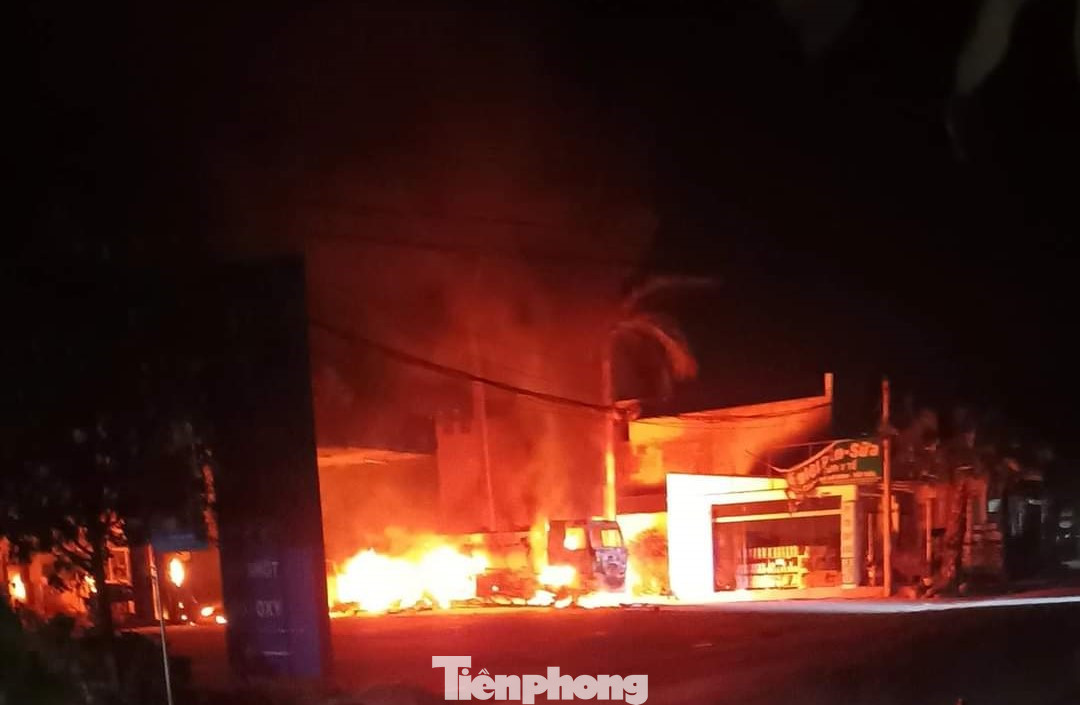 Đám cháy lan sang trụ xăng bên cạnh gây ra nhiều tiếng nổ lớn kèm khói đen kịt. Ảnh: NDCC