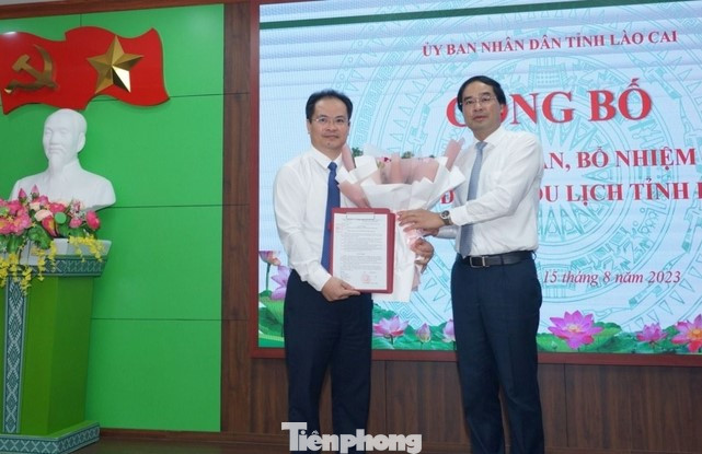 Ông Trịnh Xuân Trường trao quyết định và tặng hoa ông Lại Vũ Hiệp - tân Phó Giám đốc Sở Du lịch.