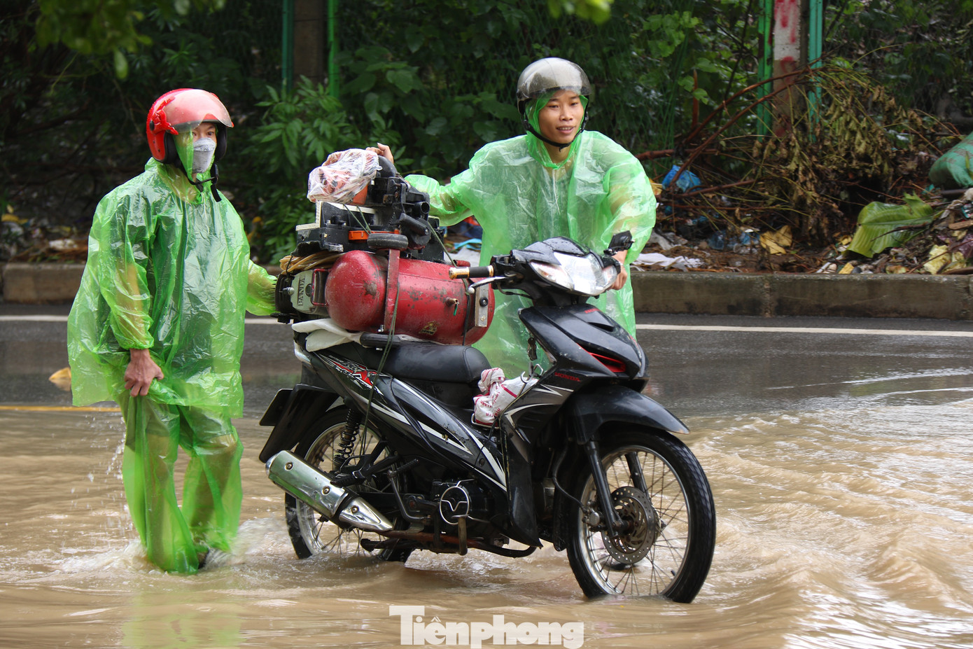 Anh Hải và chị Loan đang mang các phương tiện sửa xe từ nhà ở An Khánh, Hoài Đức ra đoạn ngập cổng chào Thiên đường Bảo Sơn. Chị Loan cho biết: "Những ngày ngập như này có rất nhiều phương tiện chết máy, vợ chồng tôi tranh thủ giờ đi làm và tan tầm mang đồ nghề ra hỗ trợ người dân, những ngày ngập sâu có thể phải sửa tới 30-40 chiếc xe bị chết máy mà còn không kịp".