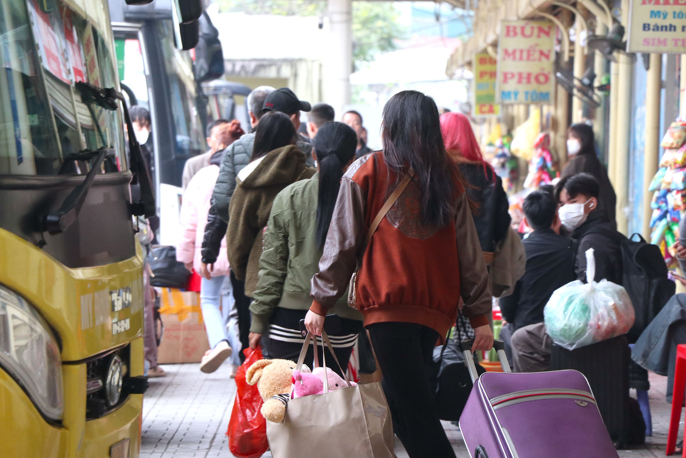 Người ngồi người đứng, mang theo hành lý, lỉnh kỉnh đồ đạc chờ xe xuất bến.