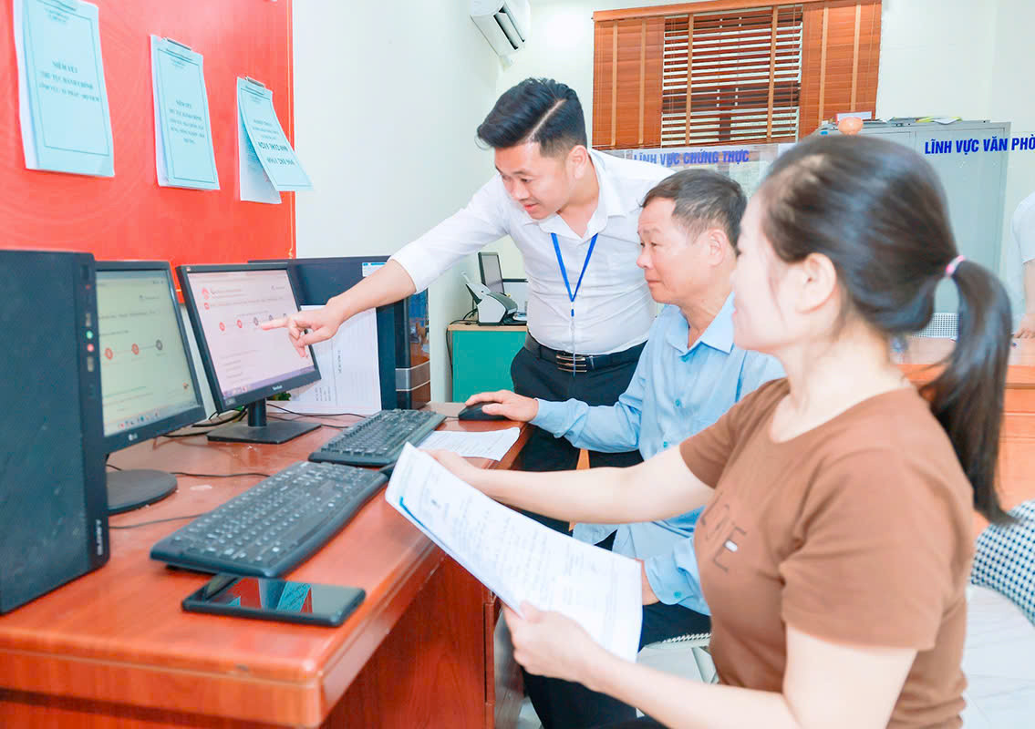 Công chức bộ phận một cửa xã Trung Mỹ, huyện Bình Xuyên hướng dẫn người dân thực hiện dịch vụ công trực tuyến - Ảnh: Báo Vĩnh Phúc.