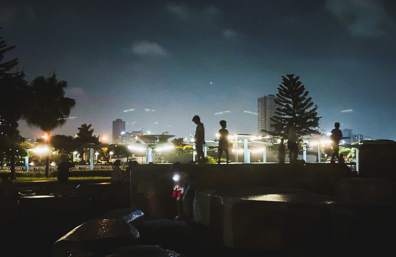 Thiếu ánh sáng, nhiều người dân phải dùng đèn điện thoại để soi đường khi đi bộ.