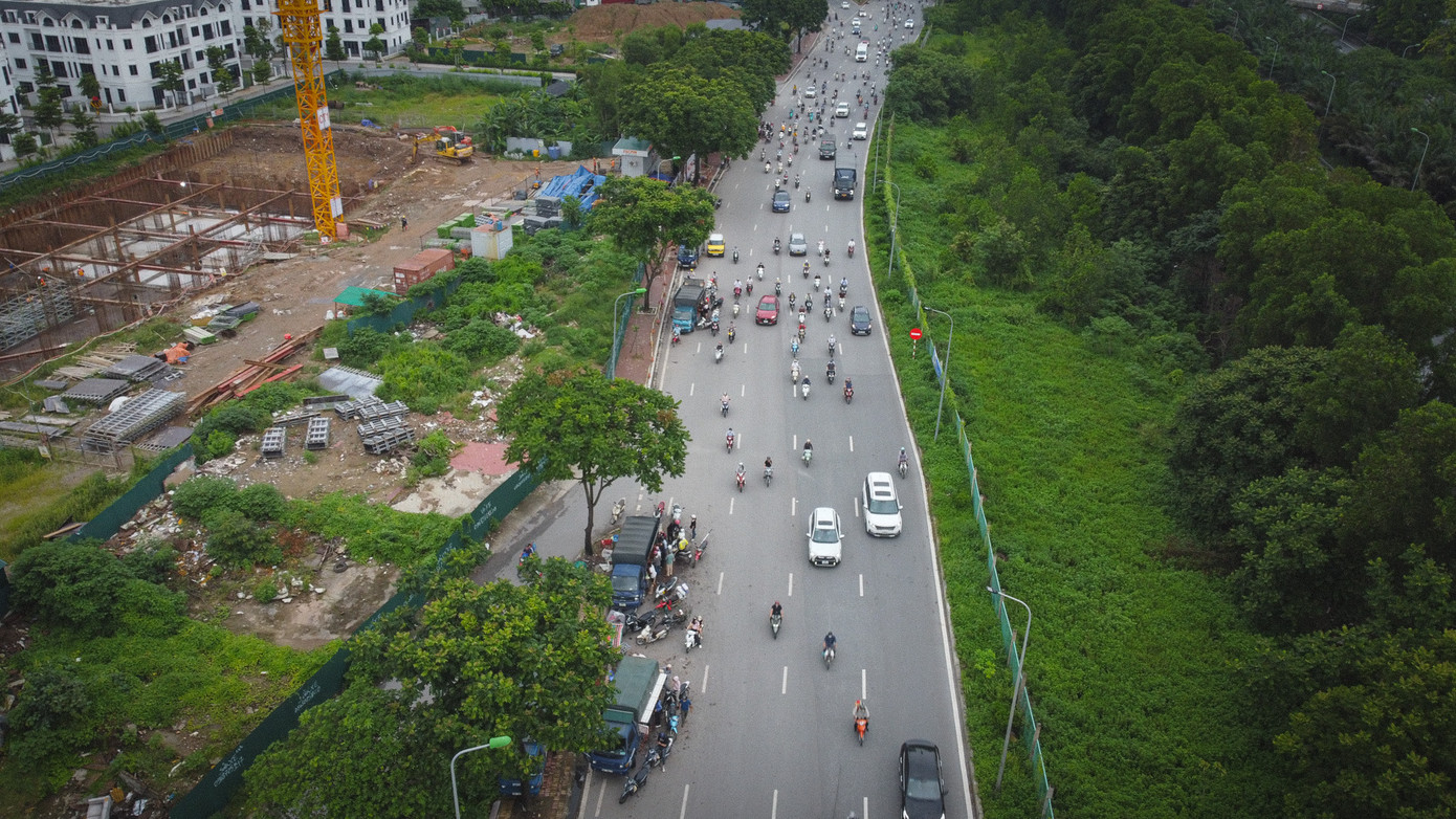 Trên đường gom Đại lộ Thăng Long, nhiều tháng nay thường xuyên diễn ra tình trạng người dân bày bán hàng hóa tràn lan từ vỉa hè xuống lòng đường; người lưu thông trên đường dừng, đỗ xe để mua hàng.