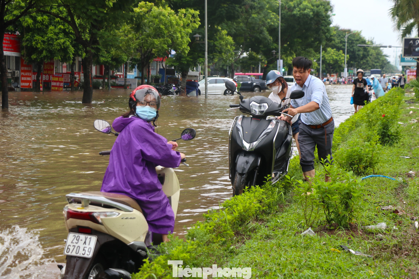 Nhiều phương tiện phải khiêng, dắt trên dải phân cách để tránh bị ngập nước.