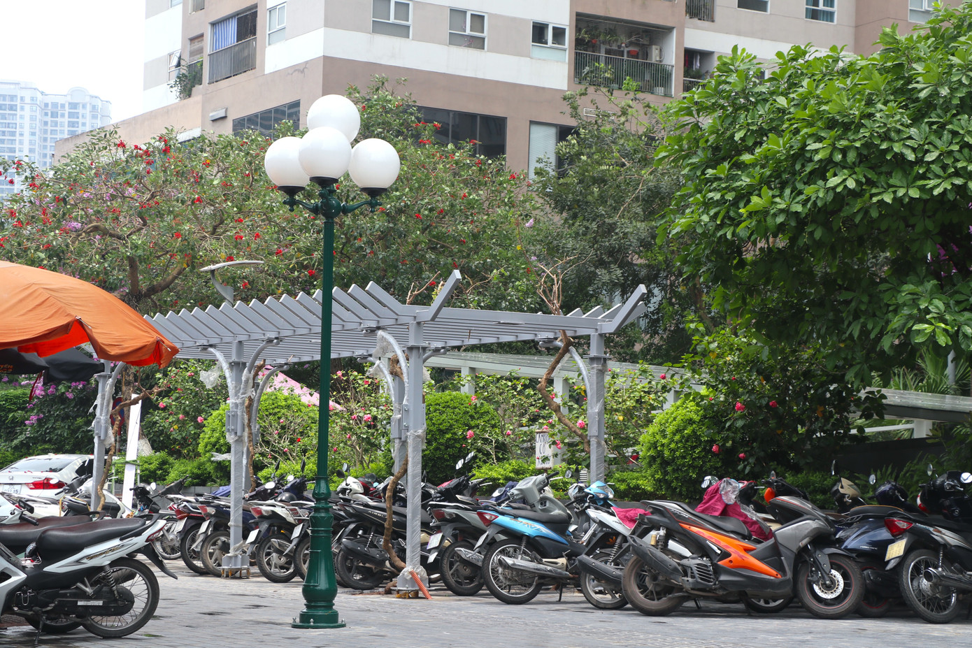 Tuy nhiên, dù chưa hoàn thiện nhưng xung quanh các giàn hoa đã bị "bủa vây" bởi nhiều phương tiện giao thông, chướng ngại vật gây mất mỹ quan.