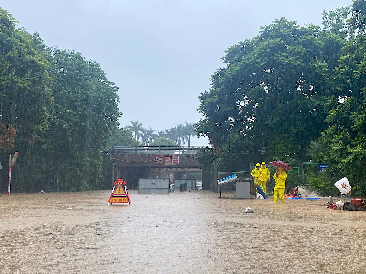 Nhân viên Công ty Cấp thoát nước Hà Nội cắm biển, dùng máy bơm để thoát nước khu vực bị ngập.