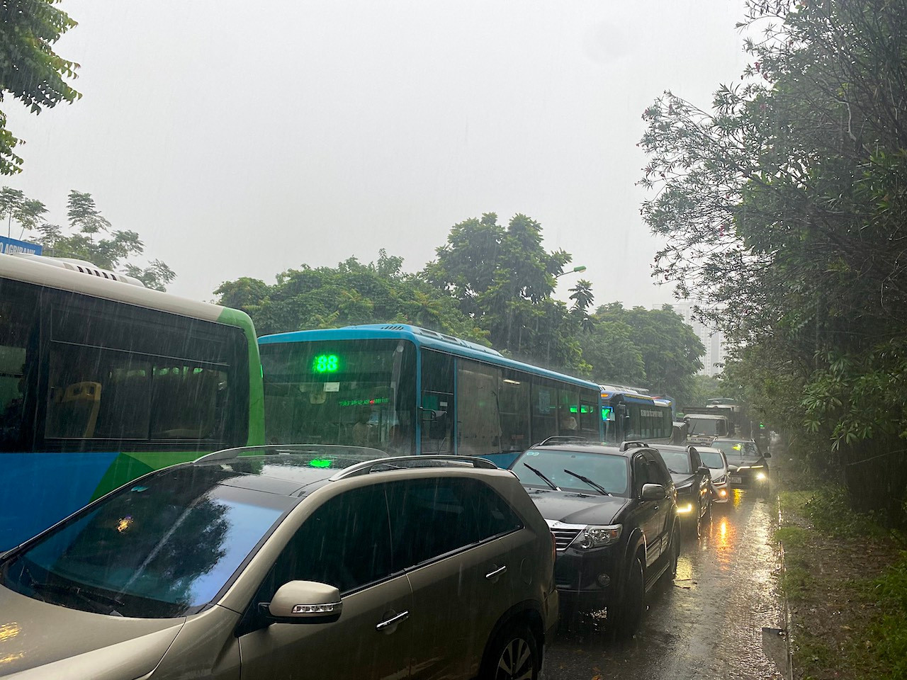 Đến khoảng 11h, tuyến đường gom Đại lộ Thăng Long càng ngày càng ngập sâu. Nhiều phương tiện "chôn chân" khiến các đoạn đường này ùn tắc hàng km.