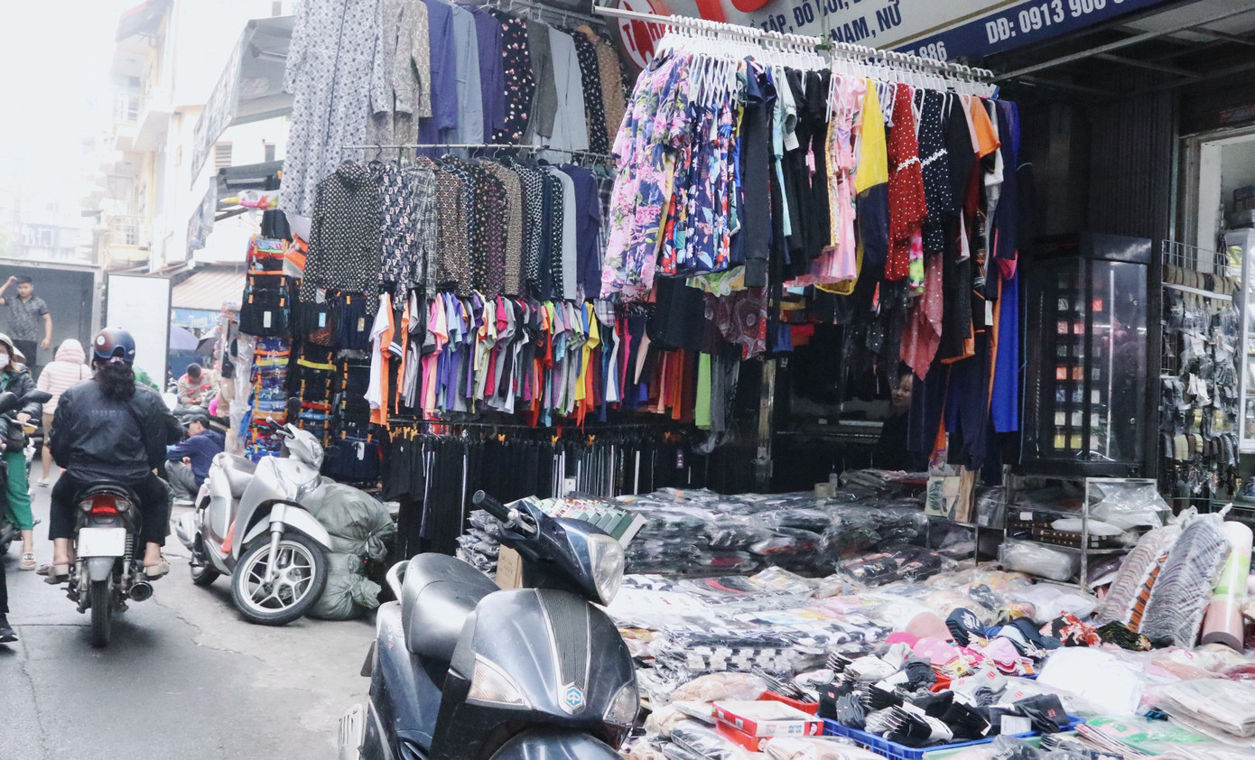 Nhiều dãy quần áo, bàn ghế, xe máy… dàn trải, phong tỏa tất cả ngõ ngách vỉa hè khiến người đi bộ không còn lối thoát.
