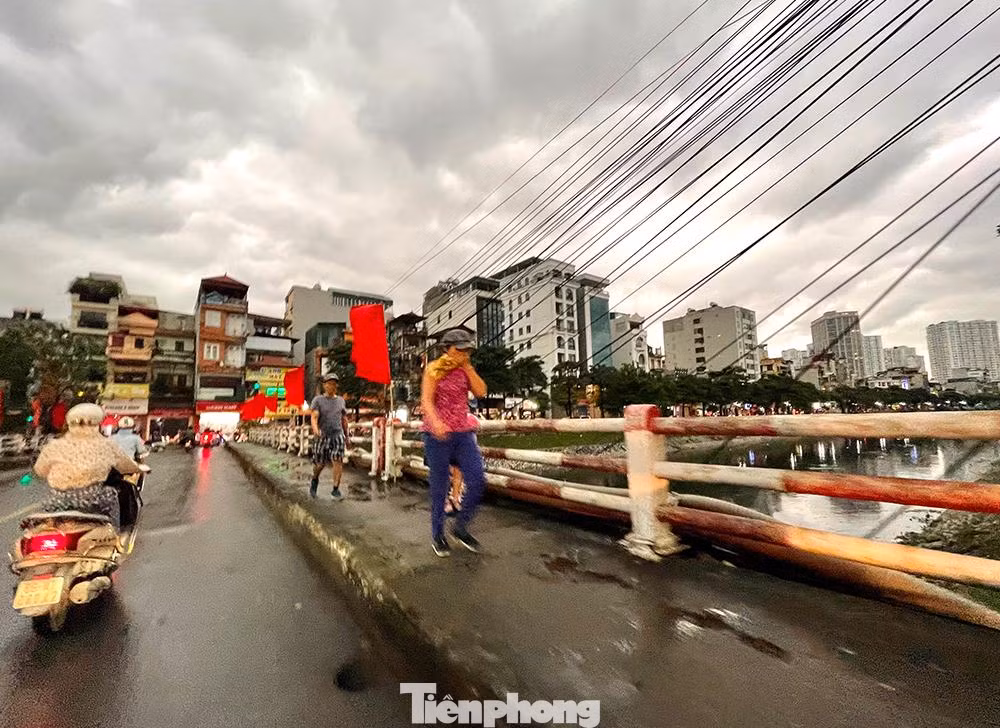 Vào 7g kém 15 phút người dân đi bộ qua cầu Khương Đình cảm nhận cơn mưa dông sắp tới