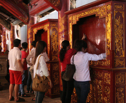 Dùng tay viết lên bảng sơn son thiếp vàng cầu mong có tên trong danh sách đỗ đạt