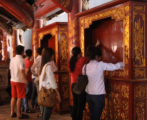 Dùng tay viết lên bảng sơn son thiếp vàng cầu mong có tên trong danh sách đỗ đạt