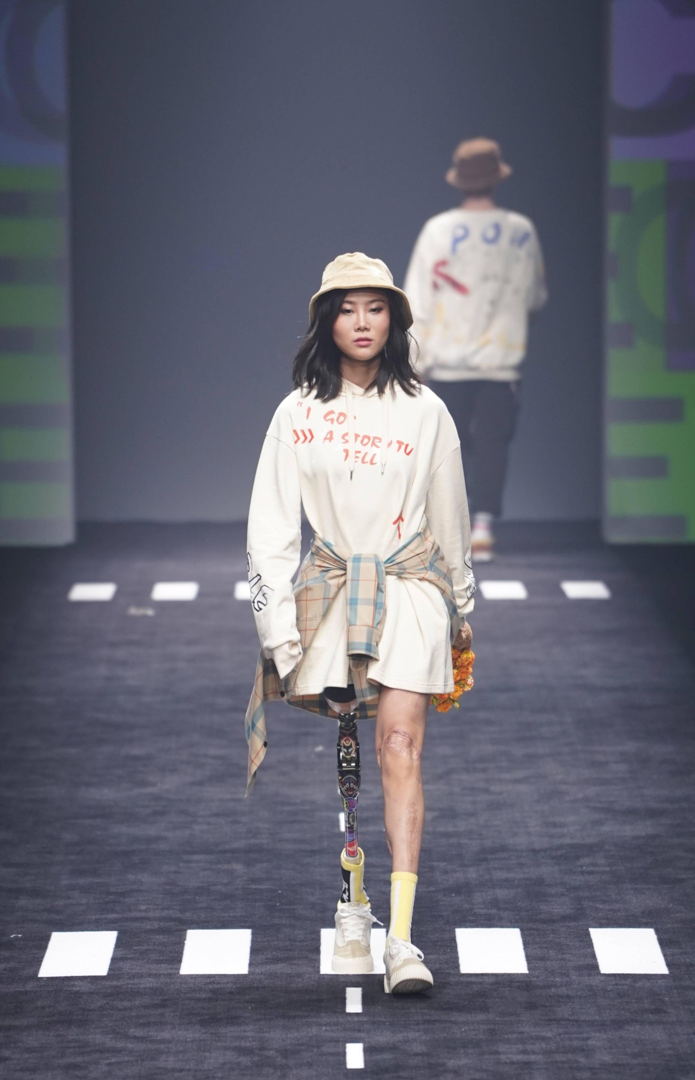 Đây không phải lần đầu Ngưu Ngọc trình diễn catwalk. Năm ngoái, cô trở thành tâm điểm khi là người mẫu khuyết tật tay/chân duy nhất được mời tham gia Tuần lễ Thời trang Thượng Hải 2021.